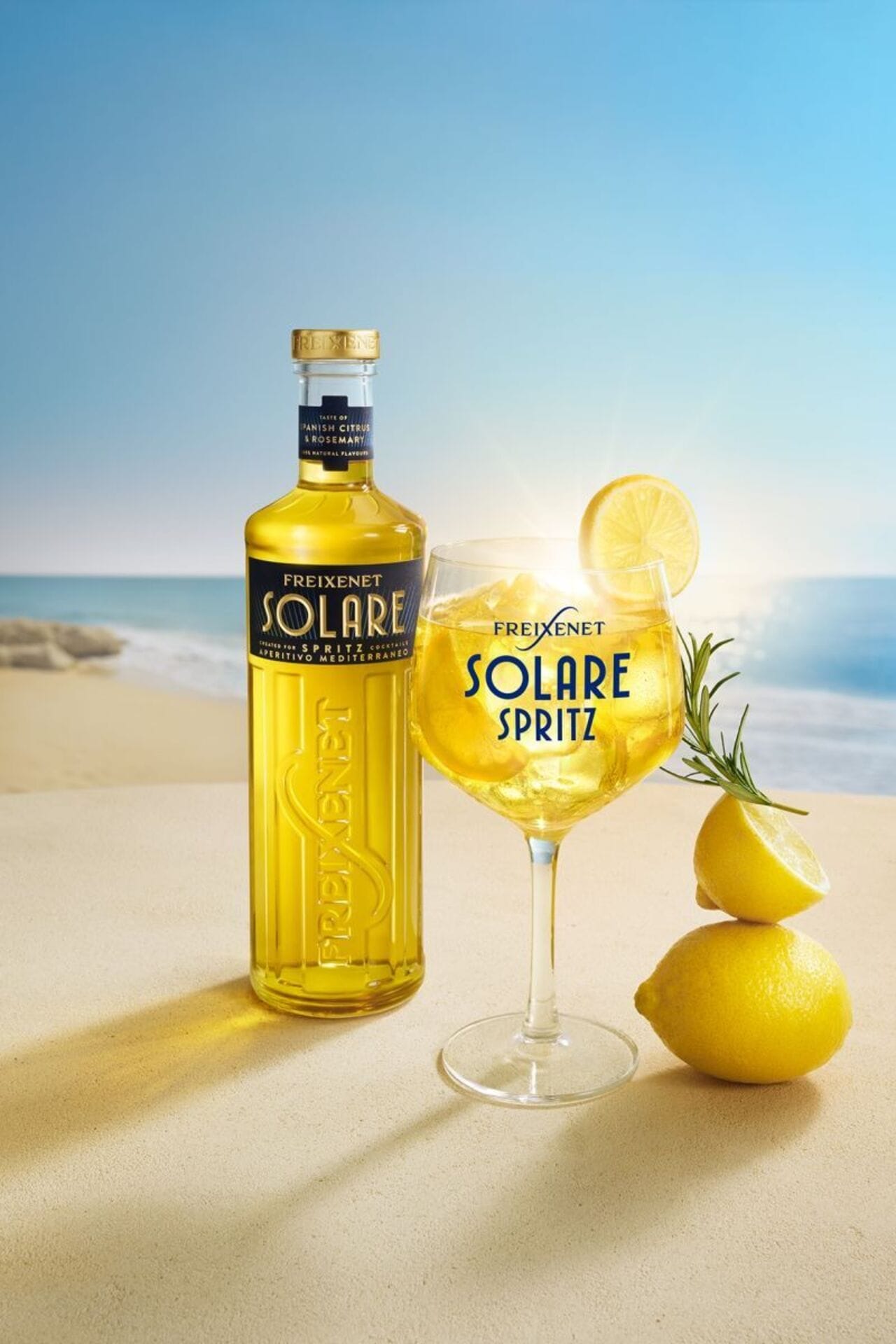 Verre ballon de Solare Spritz jaune garni de glaçons et d'une rondelle de citron